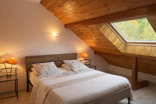 a bedroom with a bed with a large window at Le Rocher des Ducs, Chambres d'hôtes, parking privé, abris motos in Le Glaizil