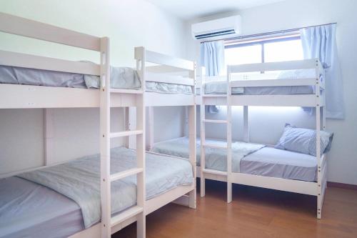 two bunk beds in a room with a window at Links Seaside resort in Futtsu