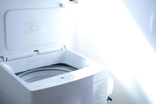 a white washing machine in a white room at Links Seaside resort in Futtsu