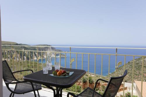 a table with a bowl of fruit on top of a balcony at Petani Bay Hotel - Adults Only in Vovikes
