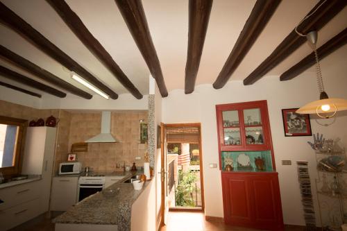 a kitchen with a red door and a counter at Cal Manyo in Puigvert de Lérida