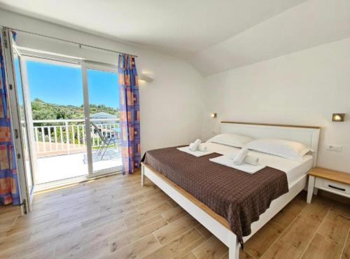 a bedroom with a bed and a large window at Adriatic Guesthouse Balota with Shared Pool in Viganj