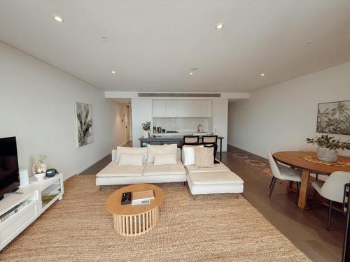 a living room with a couch and a table at Salt & Stone - Harbour Views, Balcony & Parking x1 in Newcastle