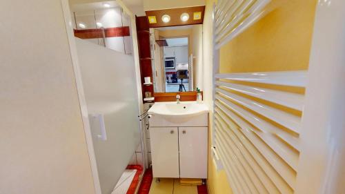 a small bathroom with a sink and a mirror at La Maison du Carbonet in Batz-sur-Mer