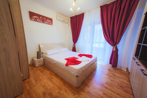 una camera da letto con un letto con asciugamani rossi di Dream Residence 64 a Bucarest