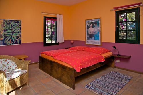 een slaapkamer met een groot bed en 2 ramen bij Casa Finca Avocado in Los Llanos de Aridane
