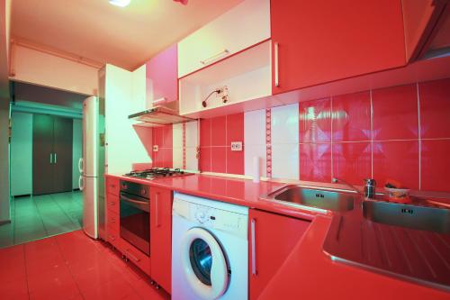 eine rote Küche mit Waschmaschine in der Unterkunft Dream Residence Nerva in Bukarest