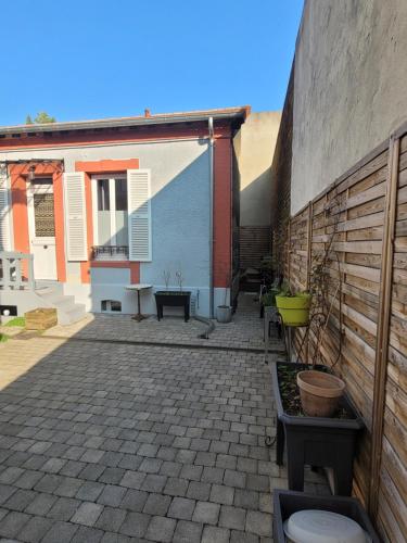 a courtyard of a building with a wall at La maison de toujours in La Garenne-Colombes