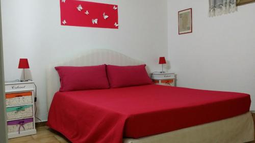Sant' IsidoroにあるChalet delle roseのベッドルーム1室(赤いベッド1台、ランプ2つ付)