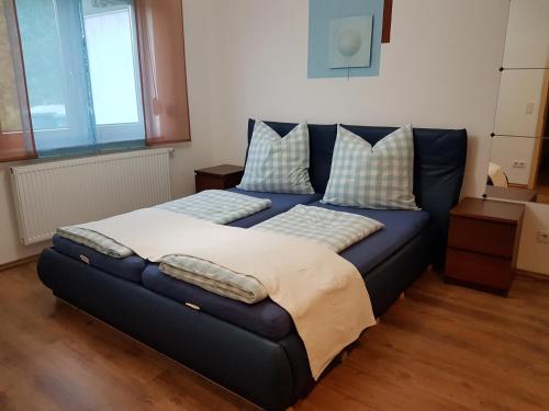 eine blaue Couch mit Kissen darauf in einem Zimmer in der Unterkunft Haus Talsperreneck in Stützengrün