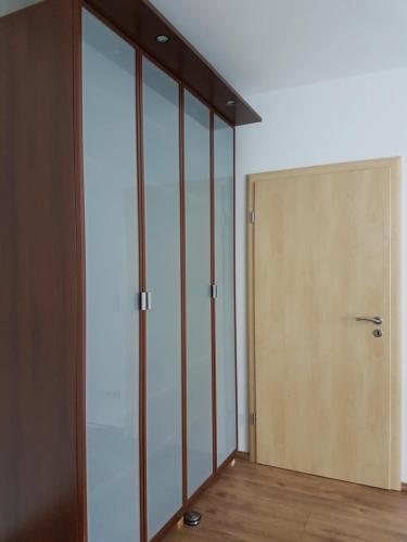 an empty room with glass doors and a wooden floor at Haus Talsperreneck in Stützengrün