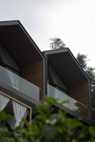 a building with glass windows on the side of it at BaanTataChiangmai in Ban Pong Khai Tai