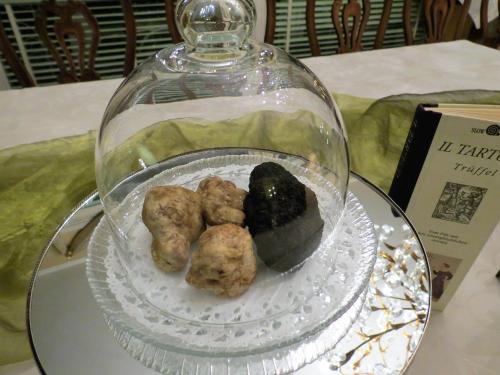 une plaque de verre avec de la nourriture dans un dôme de verre sur une table dans l'établissement Villa Morissolina, à Trarego