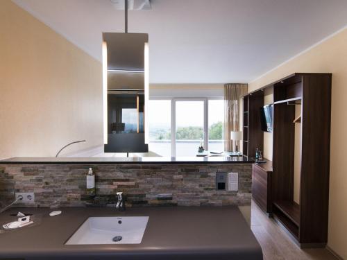 a bathroom with a sink and a large window at Design-Konferenzhotel & Restaurant Steinernes Schweinchen in Kassel