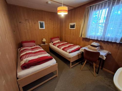 a bedroom with two beds and a chair in it at Chalet Suveran 1 in Arosa
