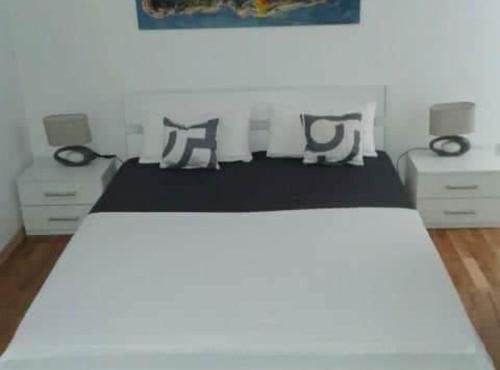 a bedroom with a white bed and two dressers at Villa Ivan Vodice in Vodice