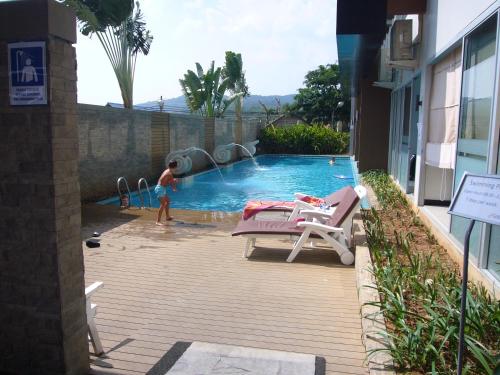 a boy is playing in a swimming pool at Chic Condominium Unit A303, A306, A307, A308, A406 in Karon Beach