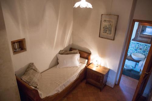 a small bedroom with a small bed with a lamp at Agriturismo La Romagnana in Pistoia