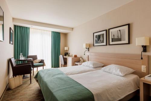 a hotel room with a bed and a desk at Hotel Aazaert by WP Hotels in Blankenberge