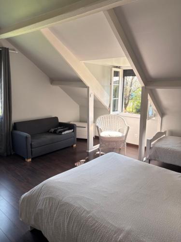 a bedroom with a bed and a couch at Le Poule House in Guérard