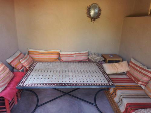 a room with a table with pillows on it at Dar Paru in Mhamid