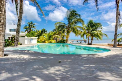 a swimming pool with palm trees and the ocean at View the Blue in San Pedro