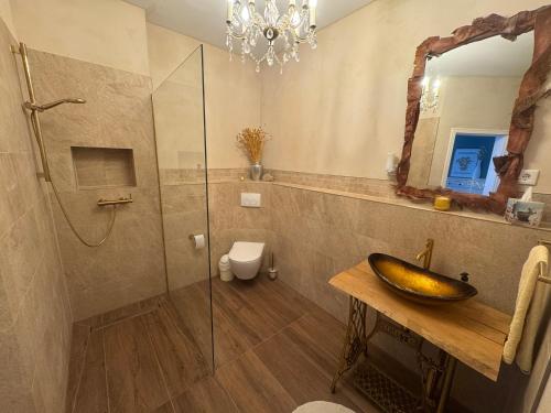 a bathroom with a sink and a glass shower at Pension "Zum Romröder Steingarten" in Romrod