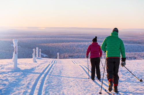 two people on skis on a snow covered slope at Kakslauttanen Arctic Resort - Igloos and Chalets in Saariselka