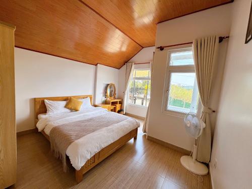 a bedroom with a large bed and a window at Tuong Vy Private Villa in Da Lat