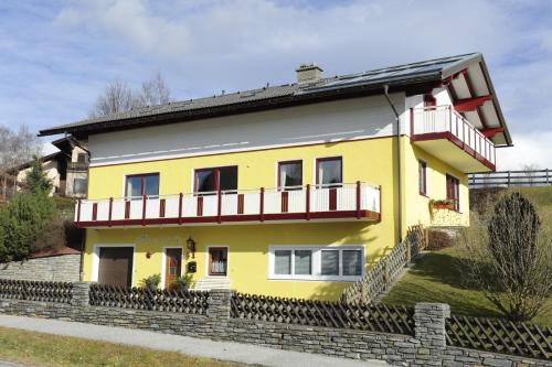 a yellow house with a balcony at Haus Sonnenschein Mariapfarr in Mariapfarr