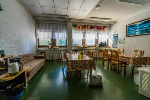 a living room with a couch and tables and chairs at Minimotel in Tohmajärvi