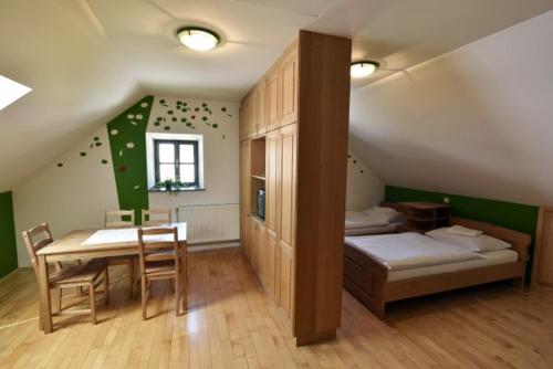 1 dormitorio con mesa, cama, mesa y sillas en Apartments Kozjanski park, en Podsreda