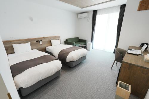 a hotel room with two beds and a desk at Hostel labeek in Fujikawaguchiko