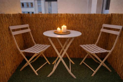 two chairs and a table with two candles on it at Le #7 - Centre ville - Parking privé - Balcon in Saint-Omer