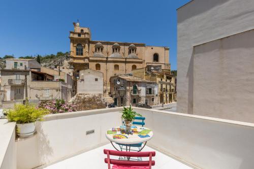 a table on a balcony with a view of a city at Scicli Albergo Diffuso in Scicli