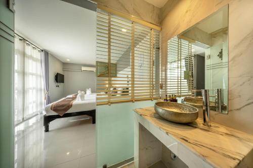 a bathroom with a sink and a mirror at WUA LAI Boutique Hotel Chiang Mai in Chiang Mai