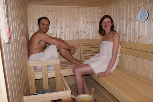 a man and a woman sitting in a sauna at Haus Annemarie in Philippsreut