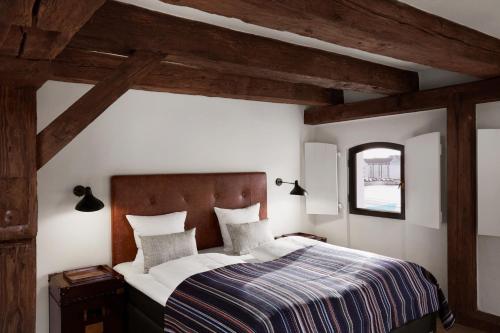 a bedroom with a bed in a room with wooden beams at 71 Nyhavn Hotel in Copenhagen