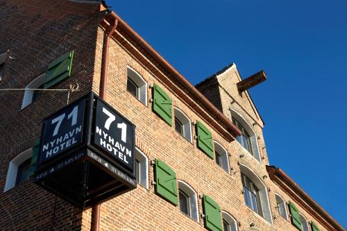 a clock on the side of a brick building at 71 Nyhavn Hotel in Copenhagen