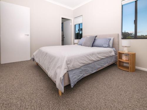 a bedroom with a large bed and two windows at The French River Chalets in Kalgan