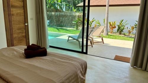 a bedroom with a bed and a view of a pool at Samma Villas - Onyx Villa - 1 BDR & Private Pool in Ko Phangan