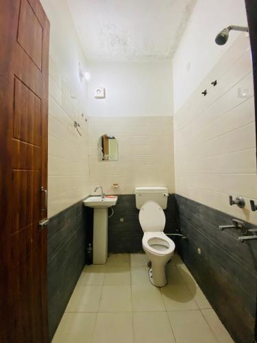 a bathroom with a toilet and a sink at Hotel Preet La Casa in Thānesar