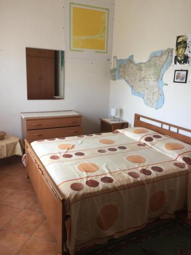 マルサラにあるCasa Vacanze Zerilliのベッドルーム1室(ベッド1台付)、壁に地図が備わります。