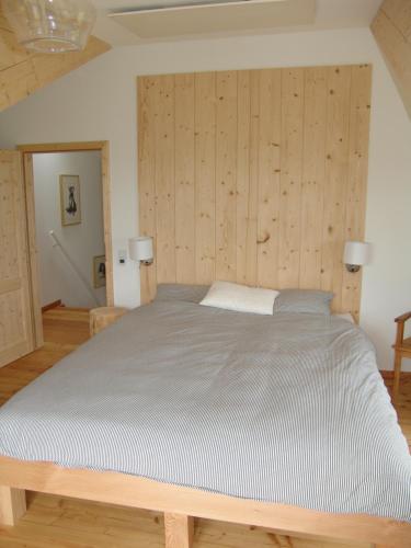 a large bed in a room with wooden walls at Ferienhaus am Nationalpark in Morsbach