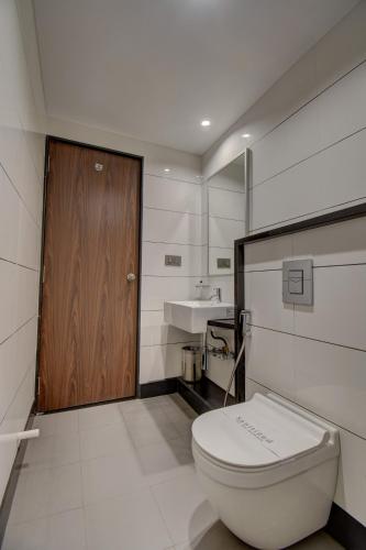 a bathroom with a toilet and a sink at Hotel Dreamland in Pune