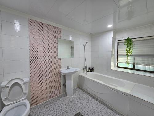 a white bathroom with a toilet and a sink at Romance Hotel in Seoul