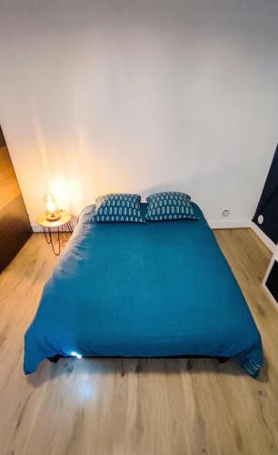 a large blue bed in a room with a wooden floor at Cocon cosy hyper-centre idéal 4 personnes in Tours