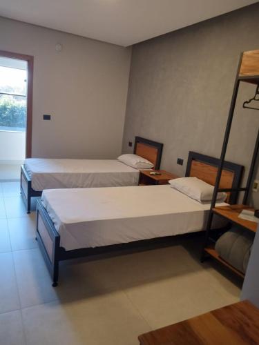 ein Zimmer mit zwei Betten in einem Zimmer in der Unterkunft Hotel Maranhão in Ourinhos
