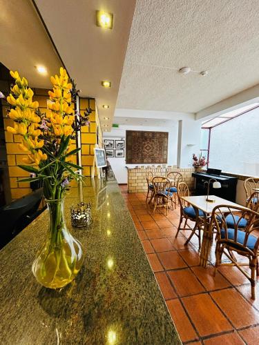 a vase with yellow flowers on a counter in a room at Hotel Apartamento Porto Covo in Porto Covo