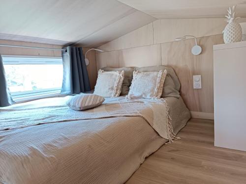 a large bed in a room with a window at Tiny house Oléroncoast La-Brée-Les-Bains in La Brée-les-Bains